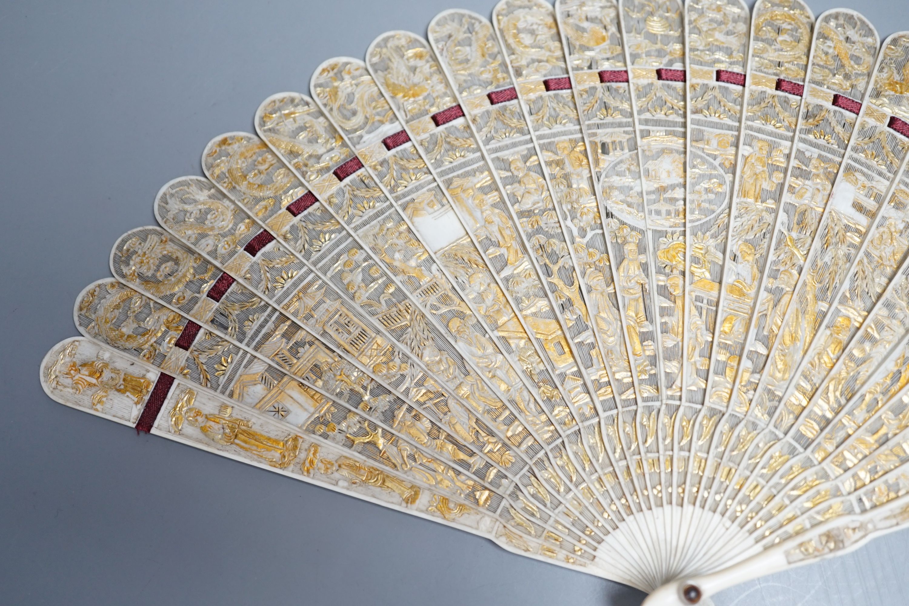 A 19th century Chinese export pierced ivory brise fan, gilded sticks, 19cm